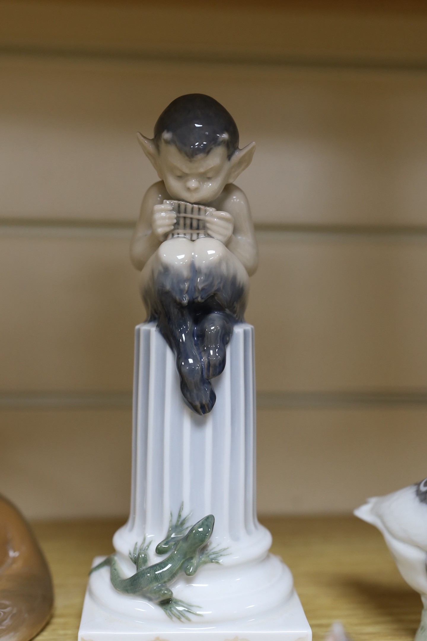 Sixteen various Royal Copenhagen porcelain birds and animals, including a faun playing pipes, a fox group and a metal foxhound, faun 21 cms high